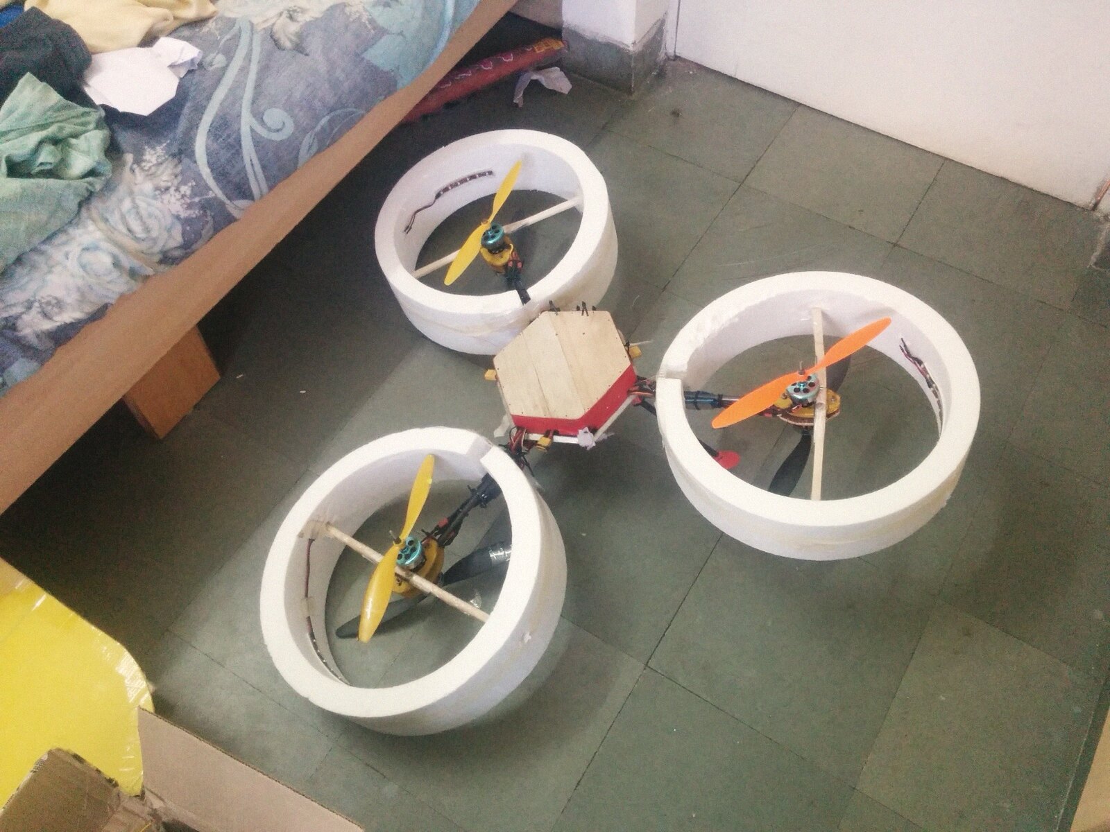 A tricopter with hand-cut thermocol duct rings around all three rotors, hexagonal wooden center plate