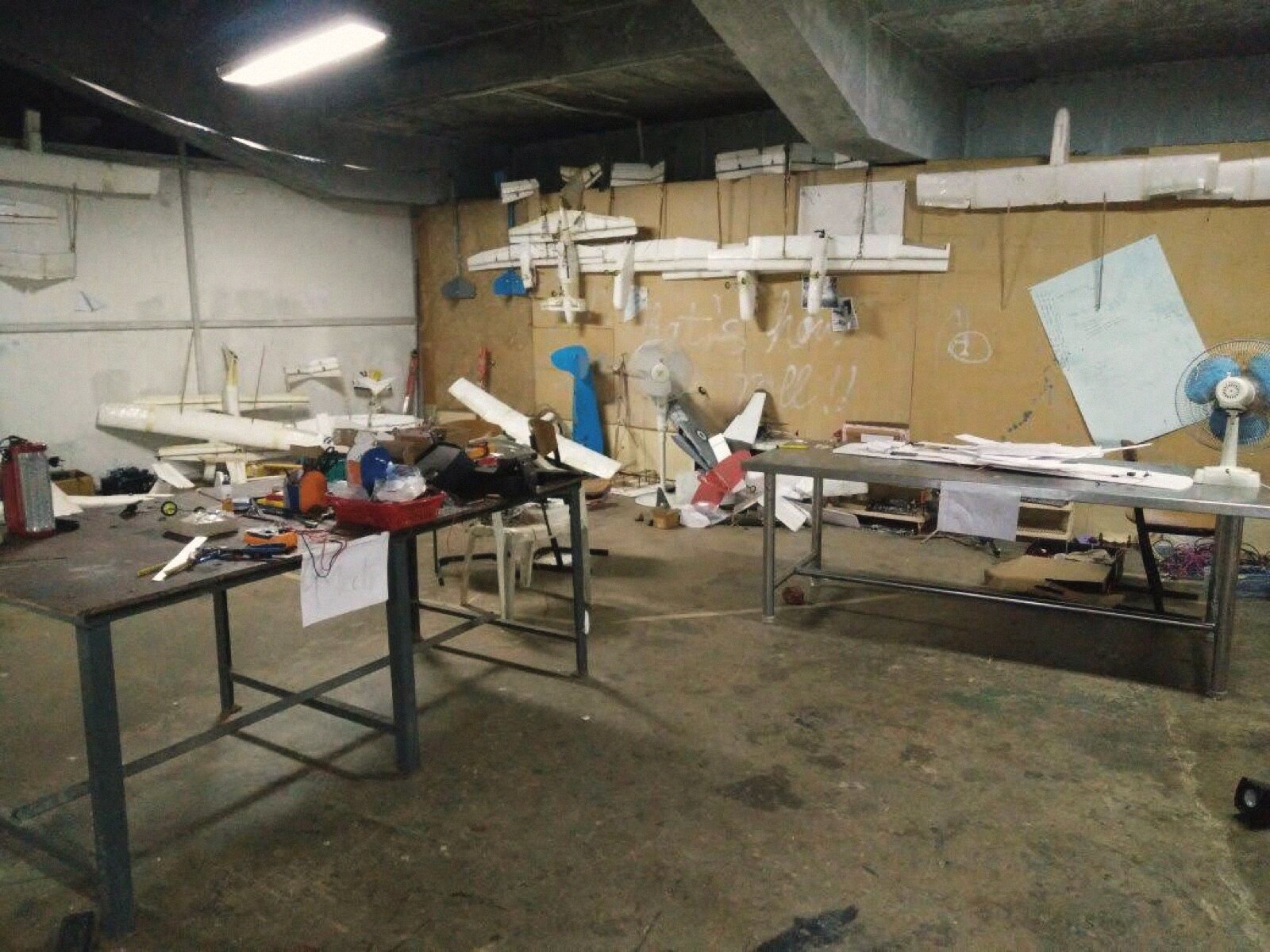 The workshop wall in September 2016, finished airframes hung in rows above the benches